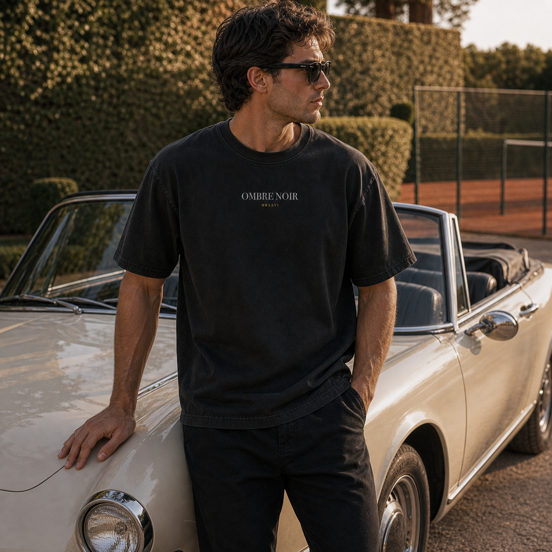 Front of black Tennis Garden T-Shirt worn beside a light-colored convertible