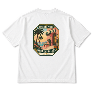 Hôtel des Palmes Graphic Tee in White, back view with palm-lined seaside hotel illustration
