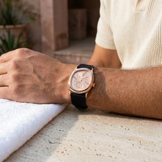 Reverie Rose Gold watch worn on a wrist beside a folded white towel