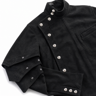 Close-up of Riven Noir jacket layered pleats and metal hardware closure