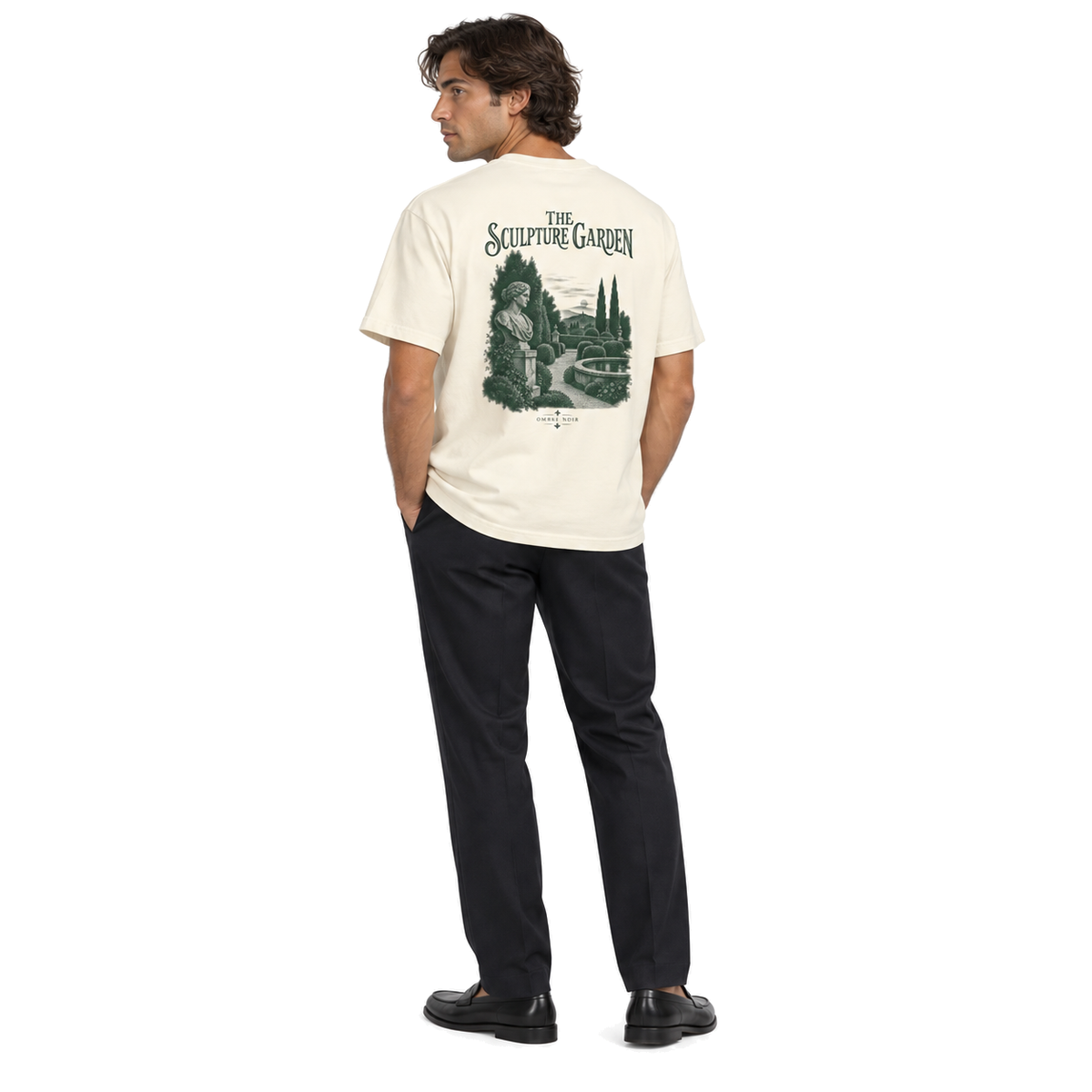 Model wearing The Sculpture Garden Faded Cream tee, full-body back view of the green garden print